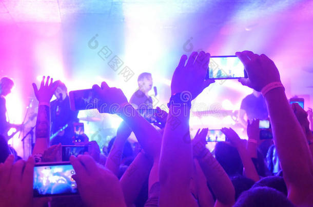 歌迷们在音乐会上用智能手机录制视频和拍照。 人们聚集在摇滚音乐会上聚会