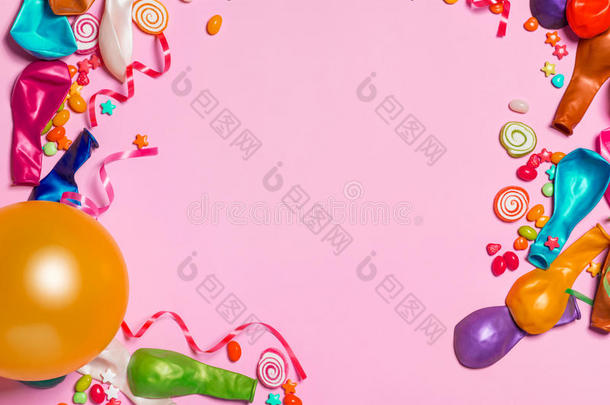 庆祝平躺。 糖果与五颜六色的派对项目在粉红色巴