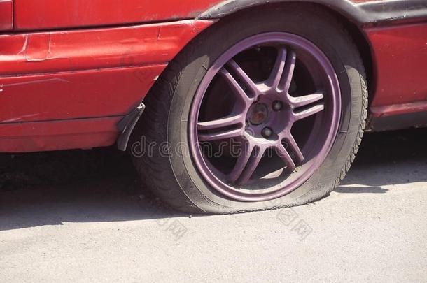 肮脏的旧红色汽车轮胎破裂<strong>泄气</strong>