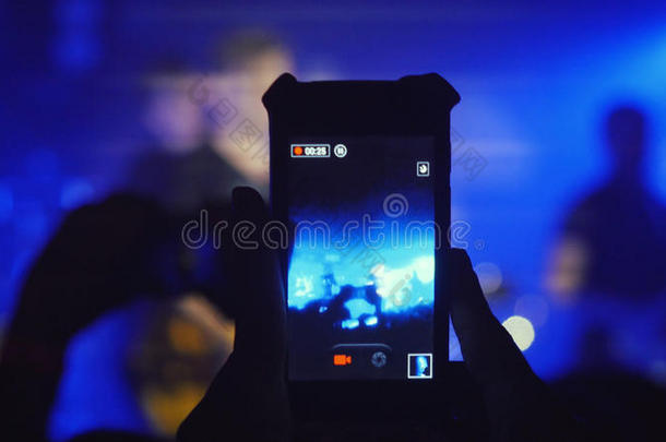 歌迷们在摇滚音乐会上用智能手机录制视频。