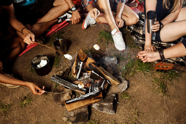 <strong>朋友们</strong>坐在篝火旁，微笑着，弹吉他。 野营<strong>烧烤</strong>棉花糖。
