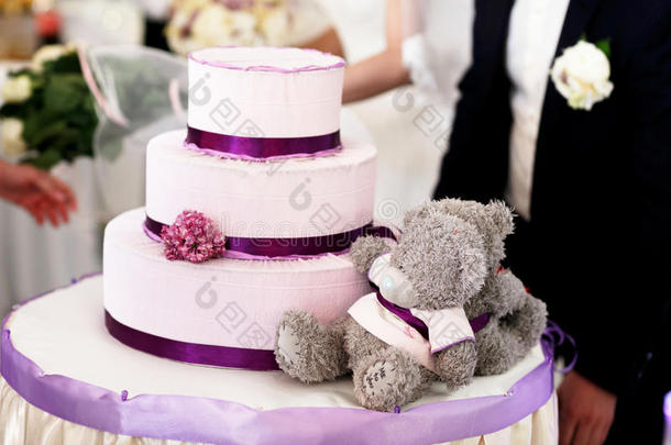 灰色泰迪熊躺在婚礼蛋糕后面