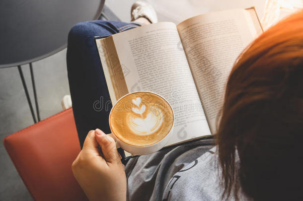 一个女孩读着书，喝着咖啡拿铁，心里怦然心动
