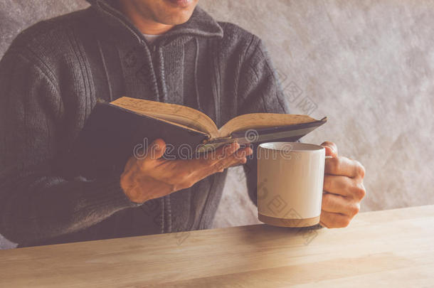 读一本书的人喝咖啡或茶