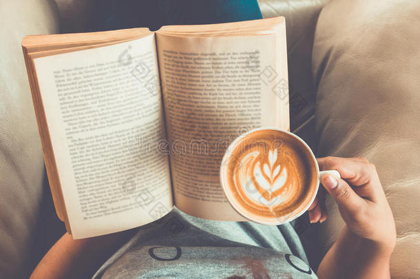一个女孩读着书，喝着咖啡拿铁，心里怦然心动