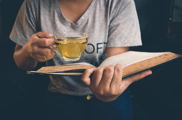 一个放松阅<strong>读书籍</strong>和喝热茶的女孩
