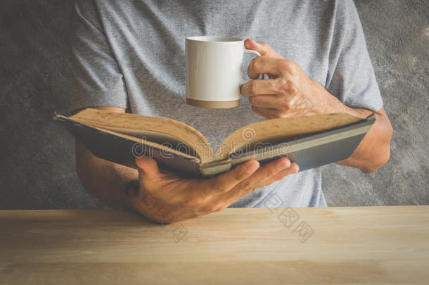 读一本书的人喝咖啡或茶
