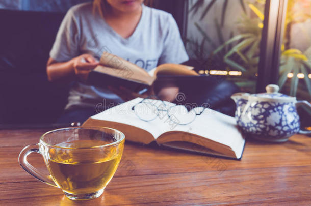 一个放松阅读书籍和喝热茶的女孩