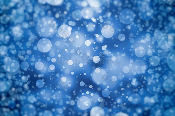 蓝色背景设计，有白色波克光或模糊、不对焦的星星或以随机模式落下的雨或雪