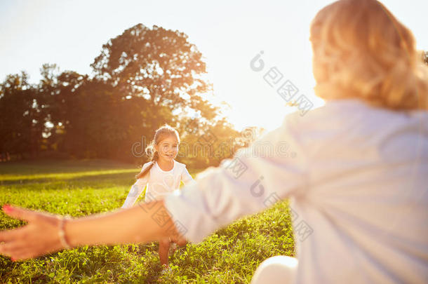 在公园里跑到她妈妈<strong>身边</strong>的女孩