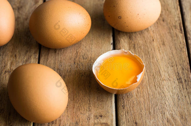 <strong>新</strong>鲜有机棕色鸡蛋散落在木桌上，打开蛋黄，<strong>简约</strong>，复活节