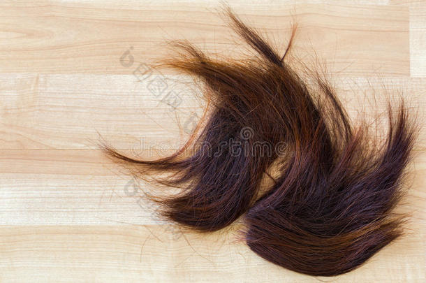 一堆修剪过的红棕色头发在木地板上