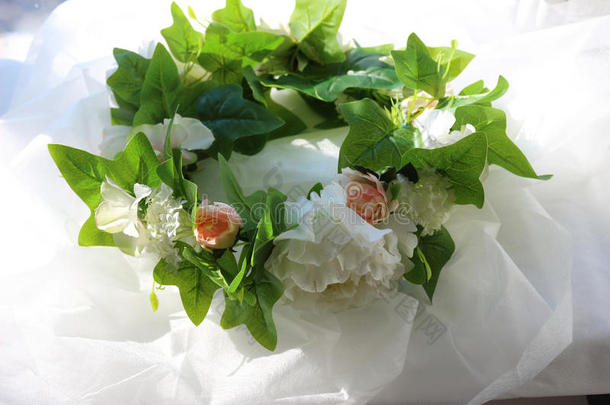 白色背景上白色花朵和绿叶的花环