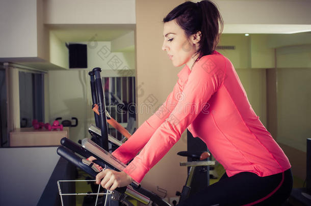 健身妇女在健身房使用自行车运动自行车