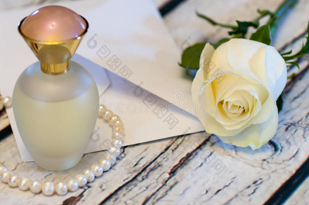 美丽的白色玫瑰串珍珠香水瓶和信封爱情人节`