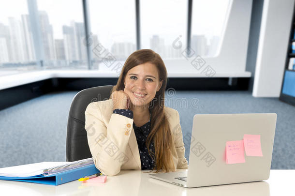 有吸引力的女人坐在办公椅上，在笔记本电脑桌上工作