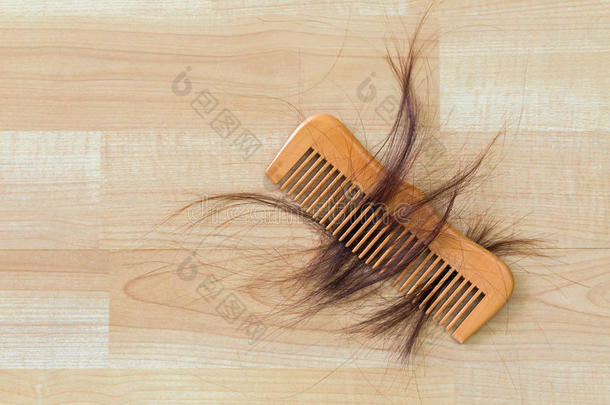 木梳上的头发在木地板上有空隙。 概念f