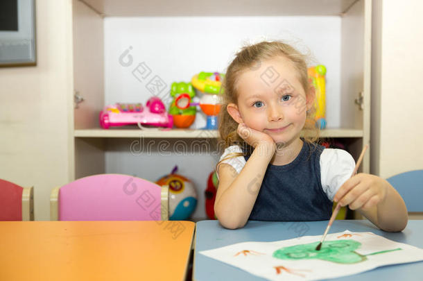 可爱的小女孩在托儿所里画画笔和油漆。 蒙台梭利学前班幼儿园的孩子。