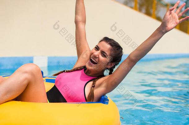 女孩在游泳池里坐在橡胶充气浮子里。