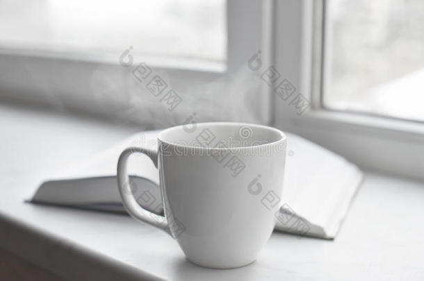 舒适的家庭静物：一杯热咖啡或茶，打开窗台上的书。 教育理念，免费复制空间