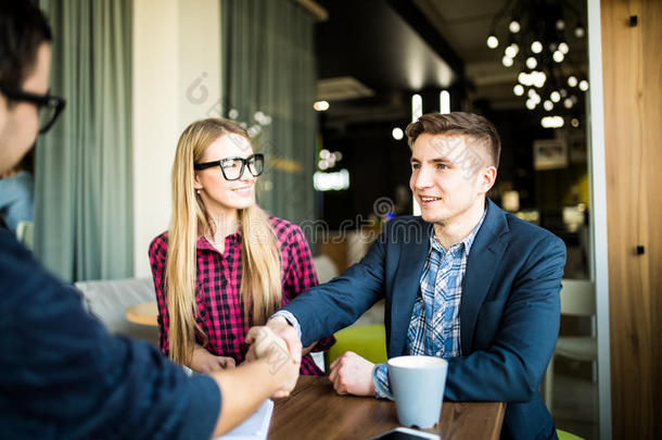 拜访房地产经纪人或经理的<strong>夫妇</strong>。 男人在<strong>握手</strong>