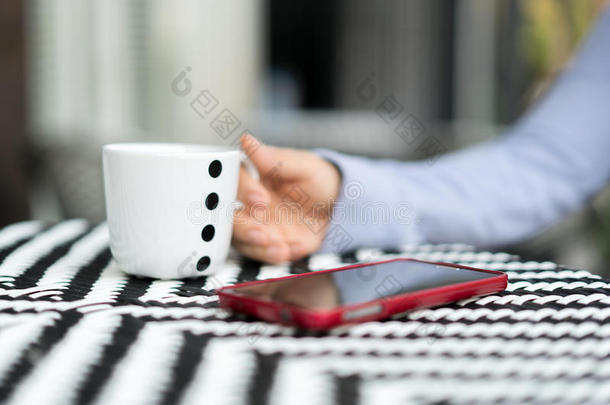 在户外咖啡馆里，亲密的女人拿着咖啡或茶杯