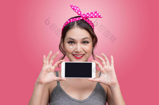 美丽的年轻亚洲妇女，<strong>化妆</strong>和发型，粉红色背景与<strong>手机</strong>
