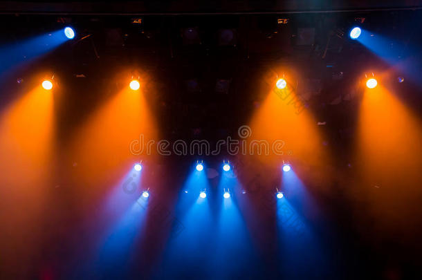 蓝色和橙色的<strong>光线</strong>穿过<strong>舞台</strong>上的烟雾。 照明设备。 聚光灯