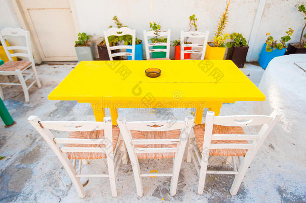 在希腊旧村庄，空荡荡的露天咖啡馆和五颜六色的桌子