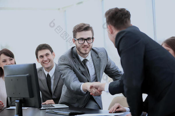 业务伙伴在你的办公桌附近握手作为首席<strong>运营</strong>官的标志