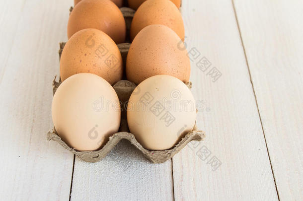新鲜鸡蛋在纸箱包装在白色木材背景