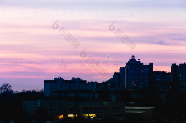 城市在日落的时候，房子的轮廓在黄昏的阴霾中，紫色