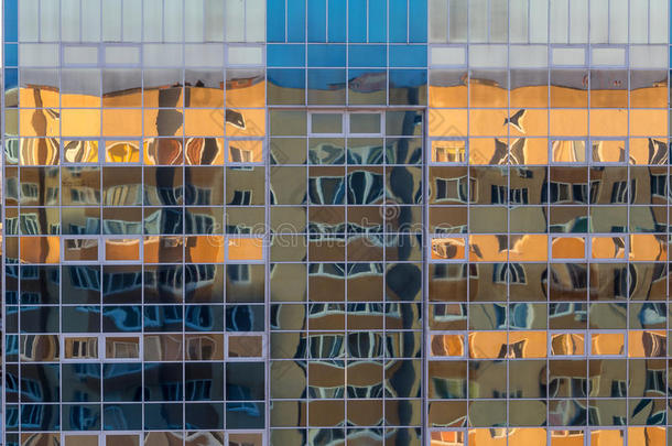 现代建筑的玻璃墙的立面与另一座建筑的倒影