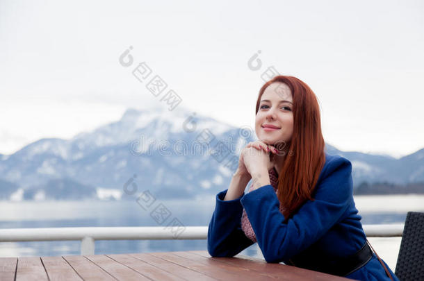 美丽的年轻女人坐在靠近<strong>桌子</strong>的<strong>山</strong>上背景
