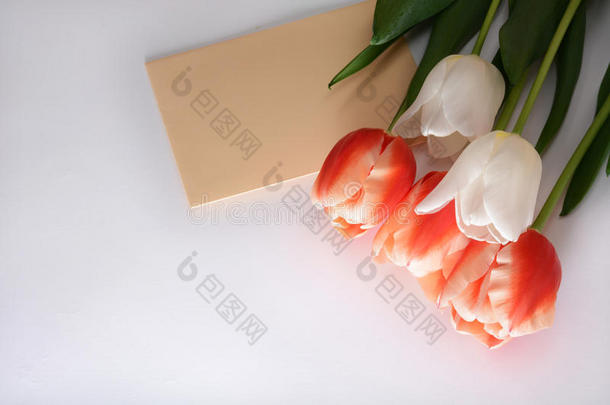 白色和红色郁金香的<strong>花束</strong>与信封隔离在白色背景上