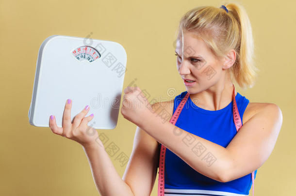 愤怒的女人用秤，减肥的时间减肥