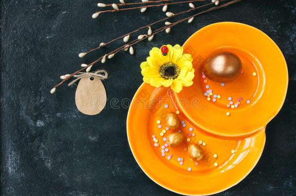 复活节假期背景，橙色盘子，金蛋，纸标签