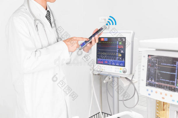 医生使用平板电脑与医疗仪器