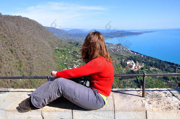 一个女人坐在一个观景台上着城市。 诺维阿丰，阿布哈兹