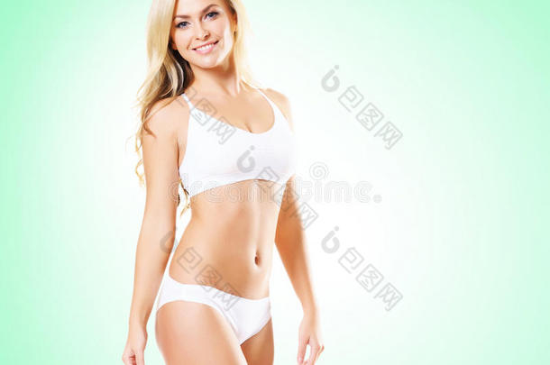 穿着白色内衣的健康活泼的女孩。 美丽健康的女人在绿色背景上摆姿势。 运动，健身，饮食，体重