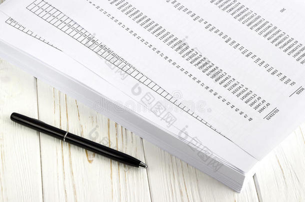 白色木制桌子上的金融纸和钢笔