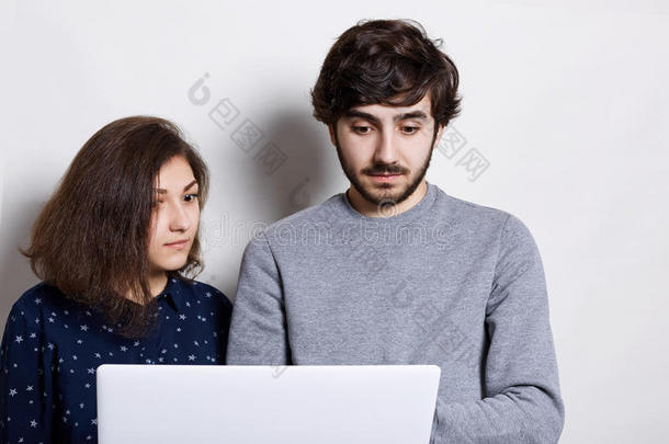 <strong>时</strong>尚的年轻<strong>时</strong>髦，留着胡子，和他漂亮的女朋友在一起，而他们坐在<strong>打开</strong>的笔记本电脑前，看上去很像