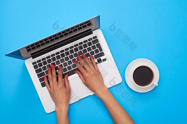 女人的手在现代笔记本电脑的键盘上蓝色的平板上