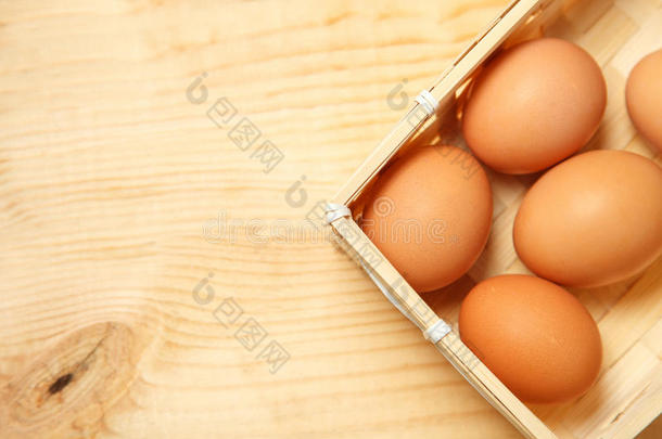 木制桌子背景上篮子里<strong>的</strong>鸡蛋。