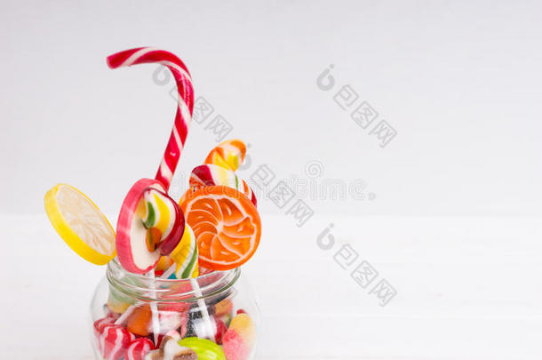 咀嚼糖果，明亮的棒棒糖与糖果拐杖和果冻糖果在玻璃罐
