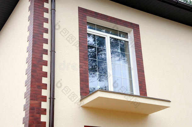 新房子里的一扇新窗户。 未完工的阳台。 装饰石膏。 装饰瓷砖。 城市房屋或建筑，立面图案。 拉