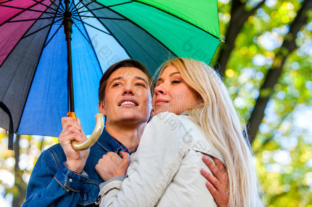 秋天的情侣步行公园。 秋天的朋友在雨<strong>伞下</strong>散步。