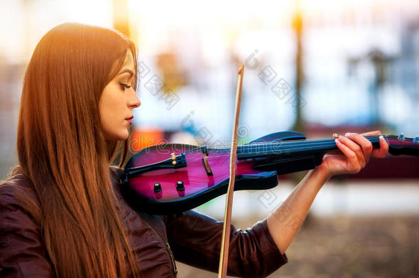 街头女子在小提琴公园户外表演音乐。 女孩表演。