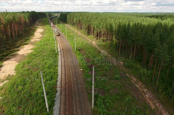 <strong>货运</strong>列车到达双线<strong>铁路</strong>，电线杆在常绿森林，鸟瞰前方的火车头