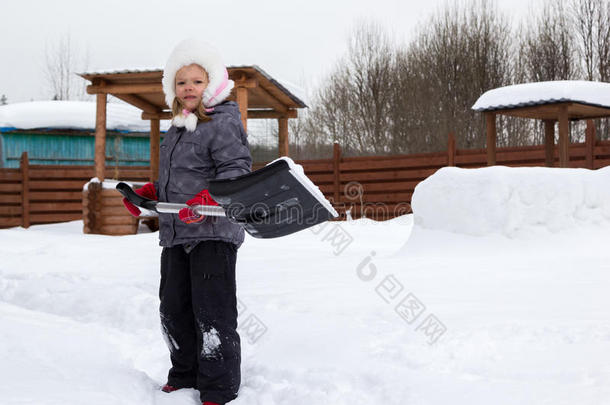 女孩用铲子把雪从<strong>跑道上</strong>拿下来